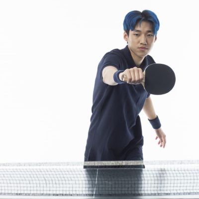 バックハンドで構える男性卓球選手