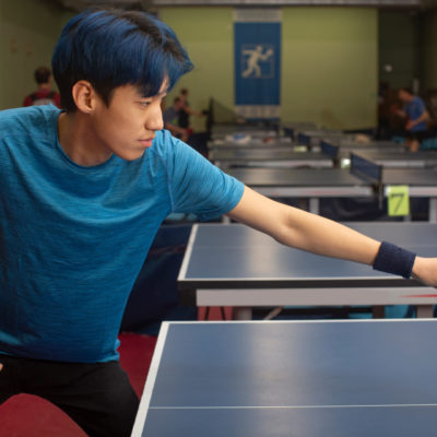 打ち返すサウスポーの卓球選手